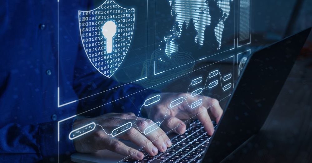 a graphic representation of a cybersecurity shield and a person typing on a laptop
